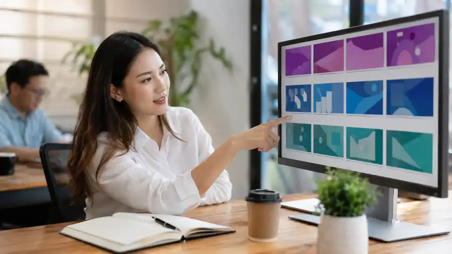 Gamma vs PowerPoint vs Canva: chọn AI tạo slide nào 2026 1 Gamma vs PowerPoint vs Canva hiển thị trên ba màn hình laptop trong văn phòng