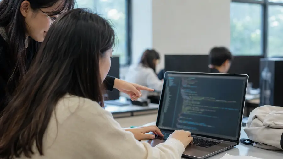 lập trình với AI — bàn tay gõ code Python trong phòng máy đại học