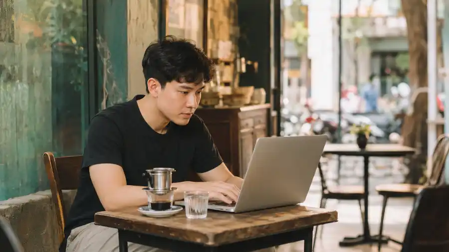 Nhịp AI tuần 24: bạn trẻ Việt dùng AI trên MacBook tại quán cà phê Sài Gòn