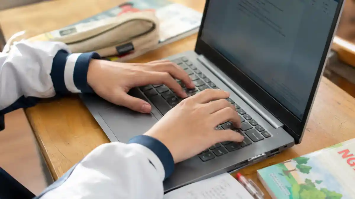 Google mở Gemini Classroom cho mọi lứa tuổi 1 Gemini Classroom — cận cảnh học sinh gõ phím laptop trên bàn học