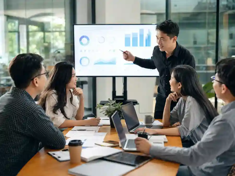 Nhóm bạn trẻ họp bàn quanh dashboard tăng trưởng AI, minh hoạ xu hướng được Nhịp AI tuần 32 phân tích.